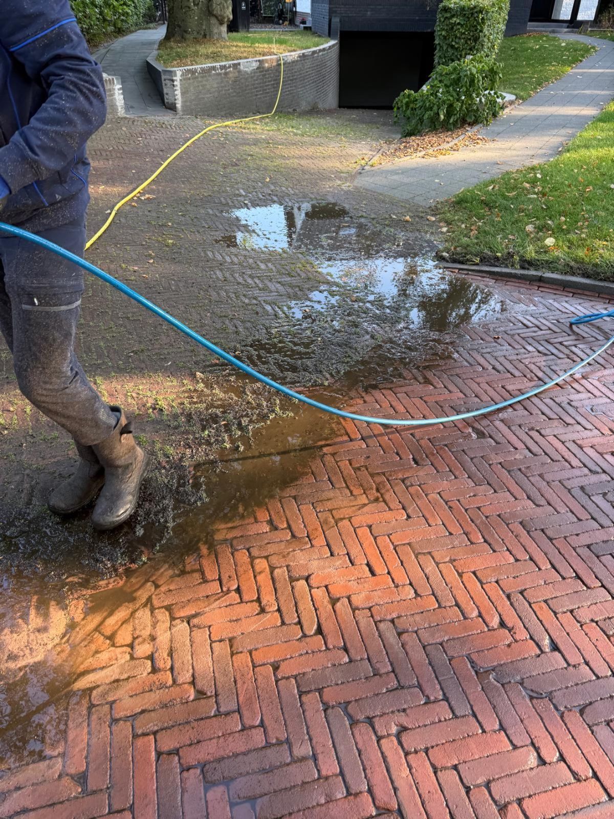 Medewerker van VDW Schoonmaak reinigt bestrating met hoge druk